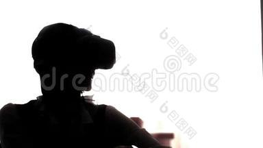 剪影年轻女子玩游戏使用VR头盔智能手机。 增强现实装置允许深入到